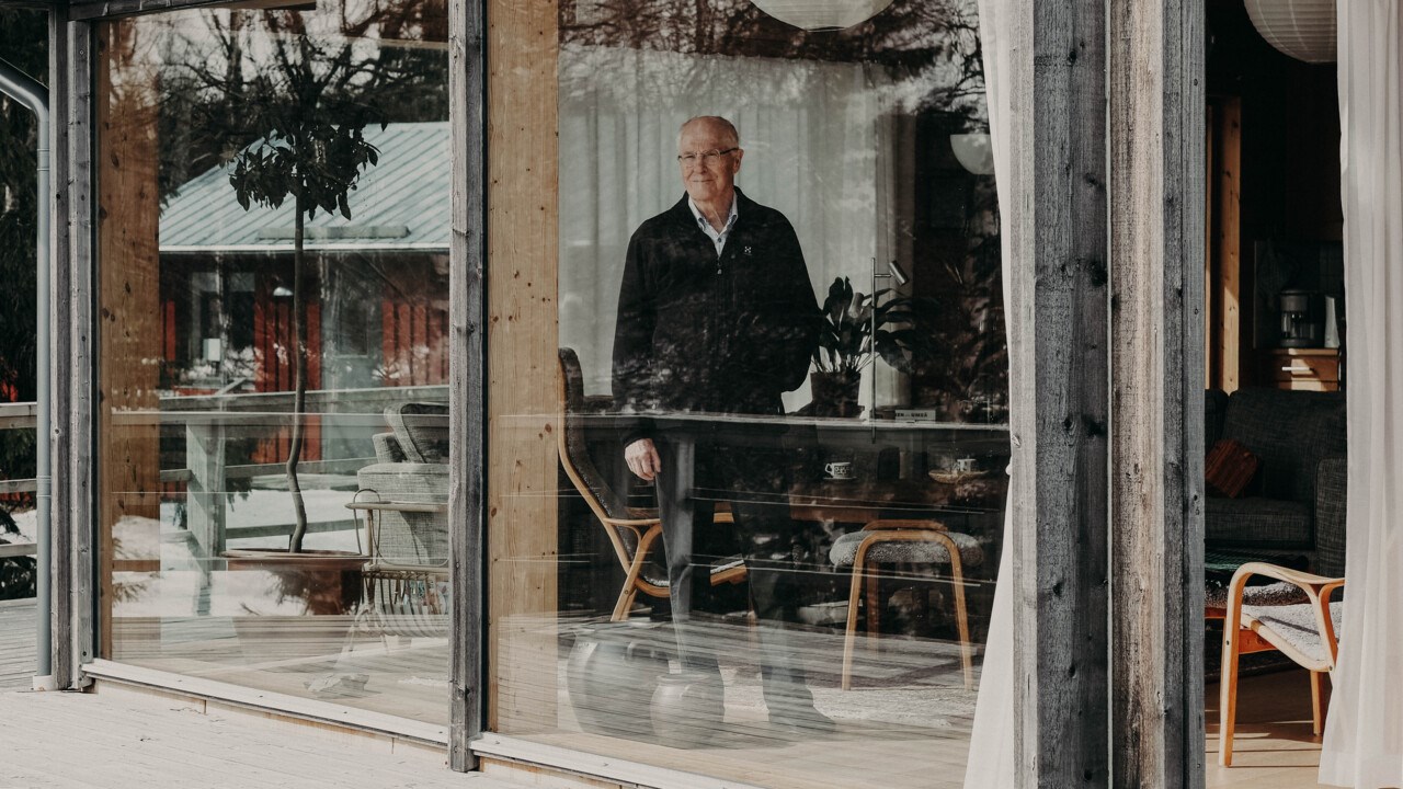 Gunnar Öquist speglas i rutan av sin stuga. 