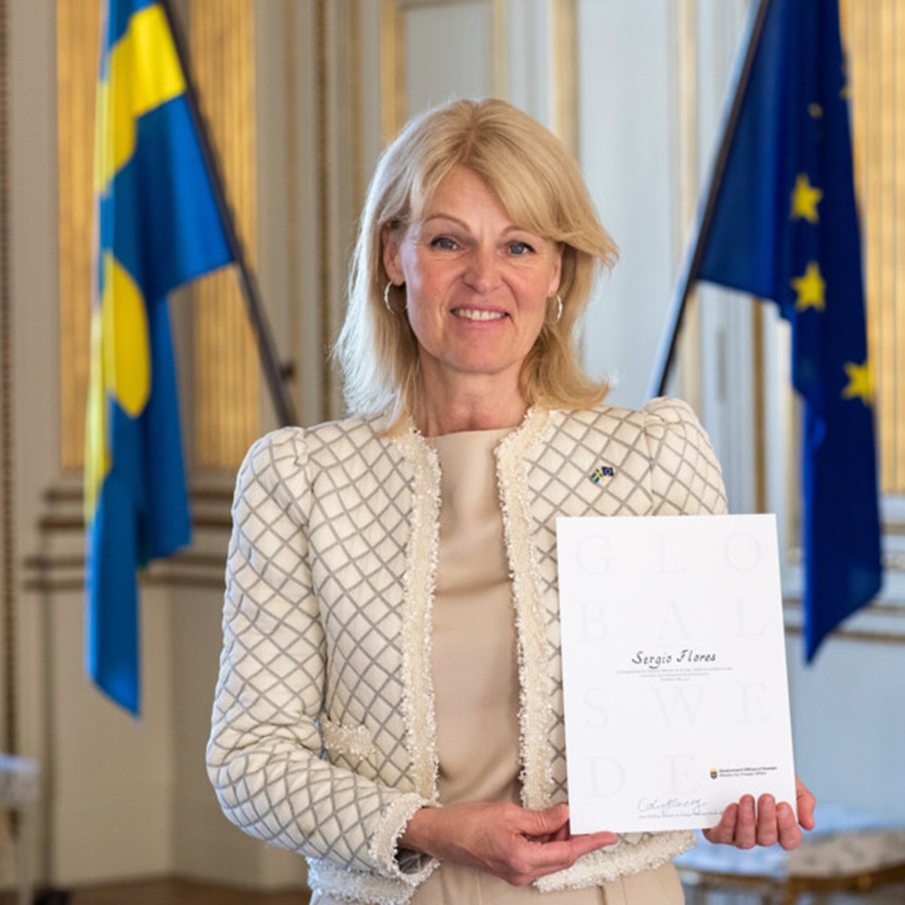 Utrikeshandelsminister Anna Hallberg håller upp ett diplom med 2021 års Global Swede vid Umeå universitet