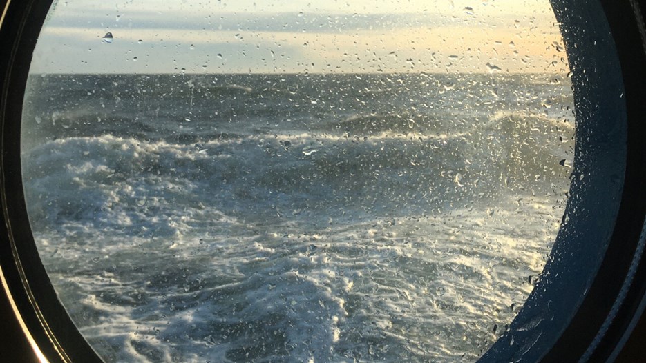 Hav med vågor som ses genom ett fartygs ventil.