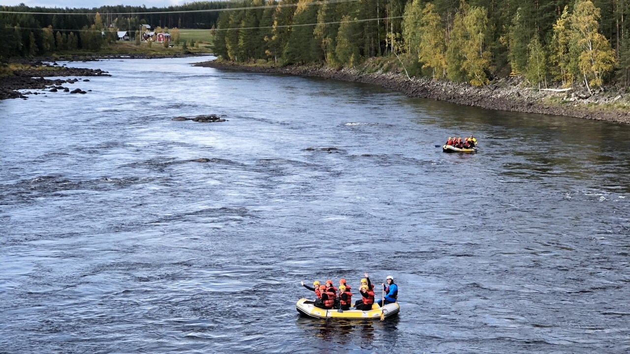 Photo of two groups who are whitewater-rafting. 