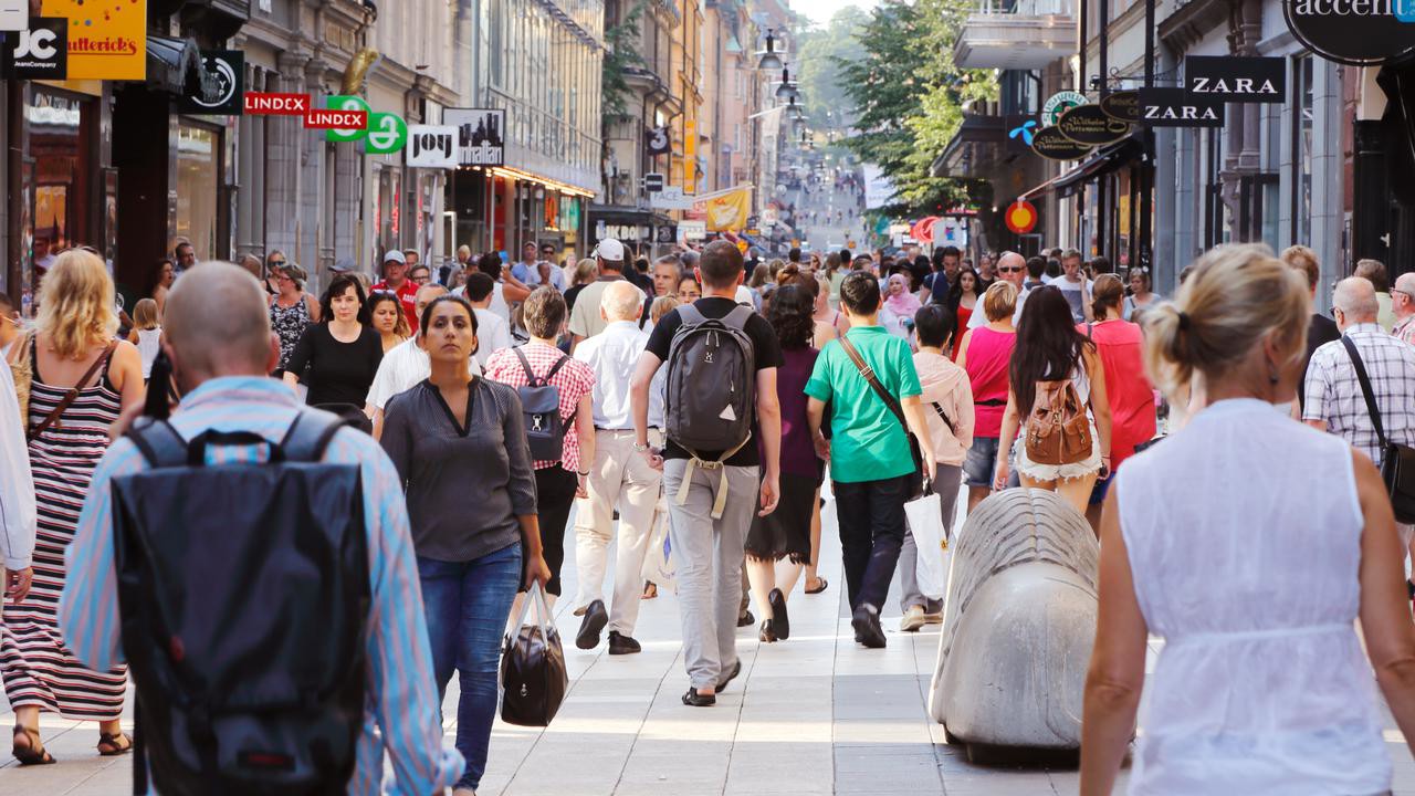 Sommardag på gågatan Drottninggatan mellan Mäster Samuelsgatan och Kungsgatan i Stockholm, Sverige, med folk i rörelse. Genrebild från Mostphtos för att illustrera stad, människor, trängsel, terrorism.