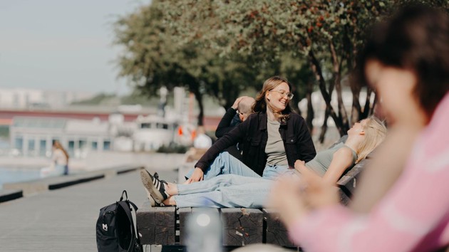 En kvinna sitter ned på en bänk.