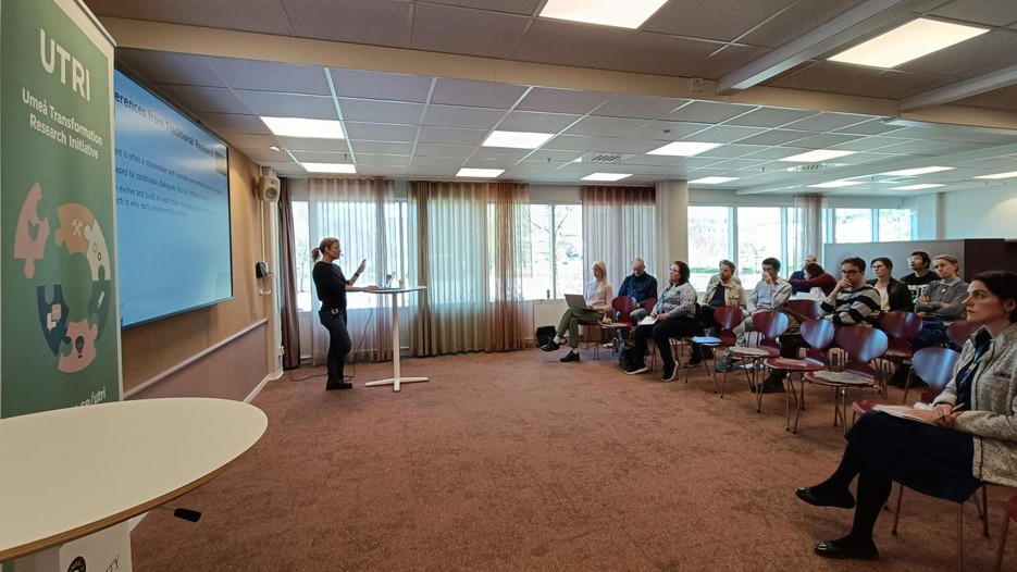 A person stands in front of an  audience.