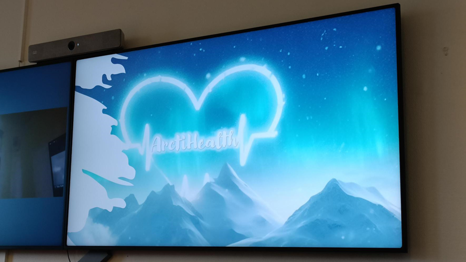 En tv-skärm som visar loggan för forskningsprojektet ArctiHealth