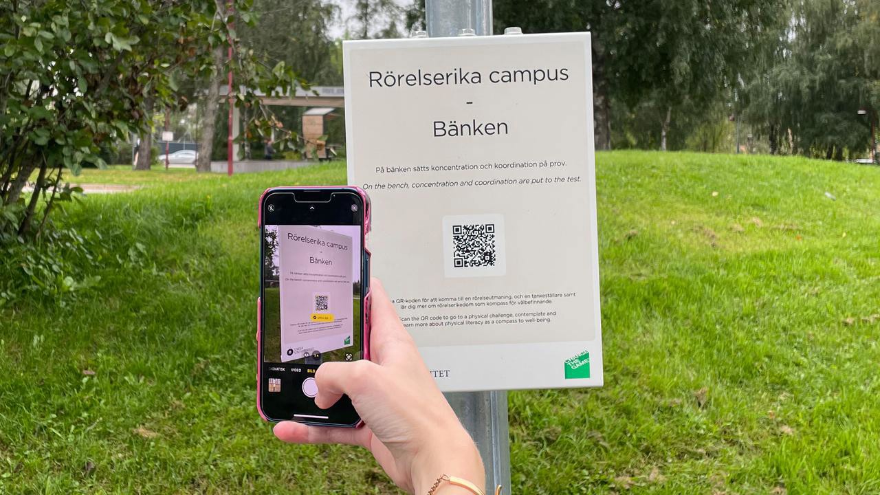 En station i programmet rörelserika campus, mobil skannar QR-kod på skylt.