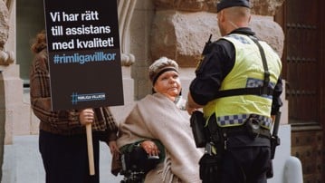 Kvinna i rullstol protesterar mot orättvisor