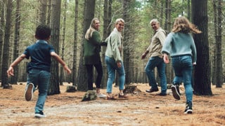 Forest, big family and adventure with children, parents and grandparents walking in nature for outdoor hiking, fun and trees on wellness vacation. Running kids, travel and happy man and women in woods