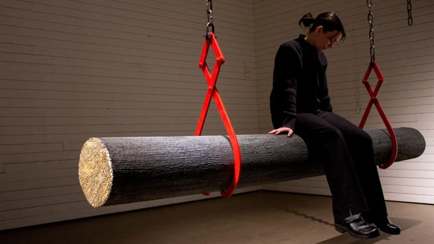 Kvinna sitter på en stock