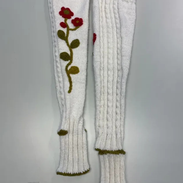 Ett par vita arvmvärmare med röda blommor på.