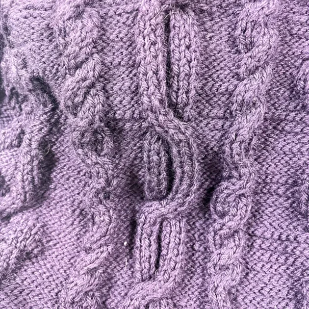En närbild av en lila stickad tröja.
