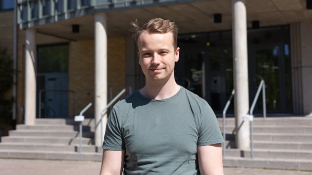 Foto på Anton Degerfeldt, i bakgrunden MIT-huset på Umeå universitet