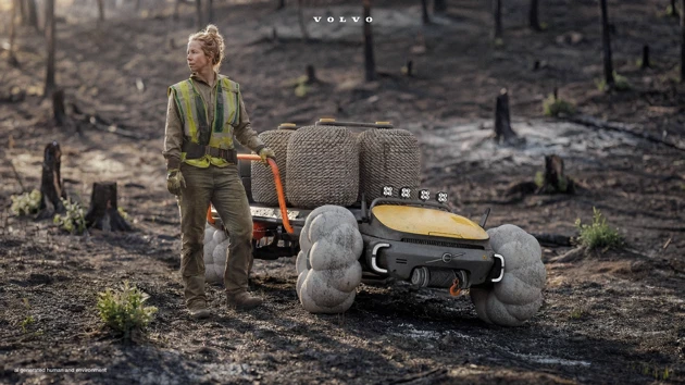 En kvinna som står bredvid en brandbil i skogen.