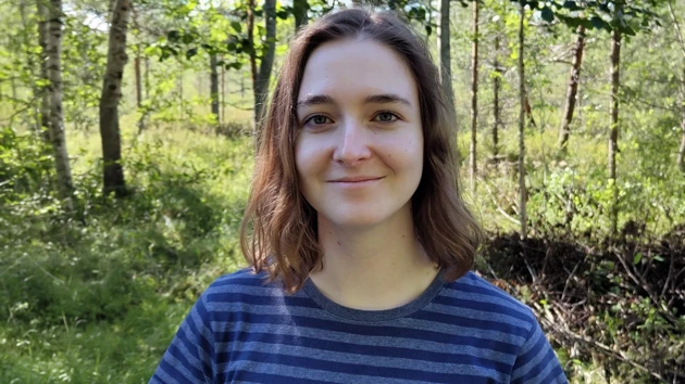 Porträttfoto på Anais de Graaf, i bakgrunden skog