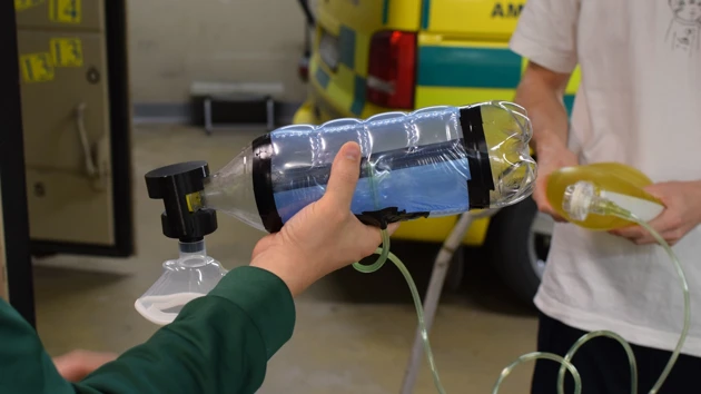 A person is pouring water into a water bottle.