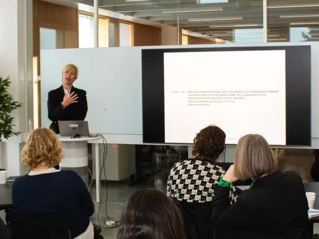 Personer som tittar på en kvinna som föreläser