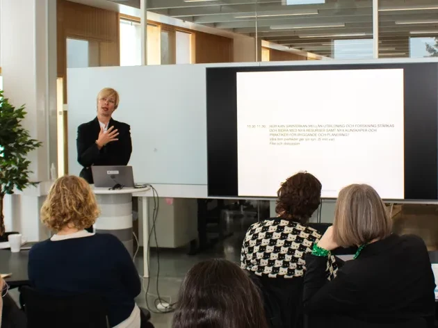 People looking at a woman holding a lecture