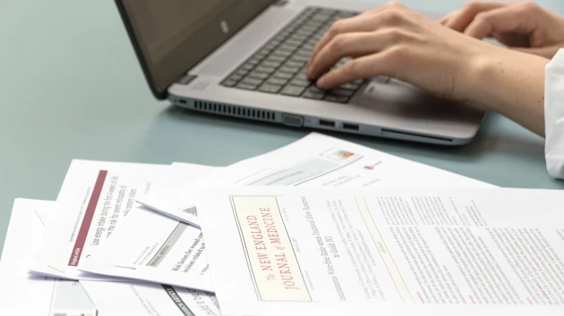 A close-up of someone's hands typing on a laptop.