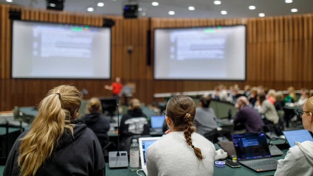 Två kvinnor fokuserar koncentrerat på en föreläsning i en av Campus Umeås nyaste föreläsningssalar. 