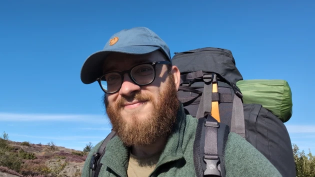 Porträttfoto av Bastian Schiffthaler med keps och ryggsäck