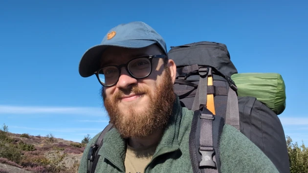 Portrait photo of Bastian Schiffthaler wearing cap and rucksack