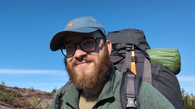 Portrait photo of Bastian Schiffthaler wearing cap and carrying rucksack