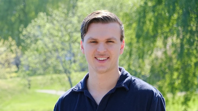 Carl Göransson sittandes framför campusdammen.