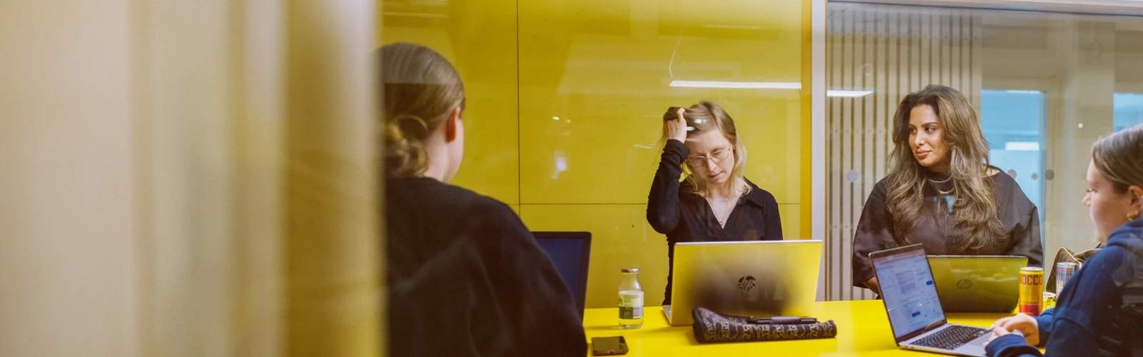 Umeå Universitet, Humanisthuset. Studenter pluggar i ett gult grupprum.