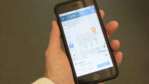 Bild på hand som håller mobiltelefon som visar den digitala kartan över campusområdet.