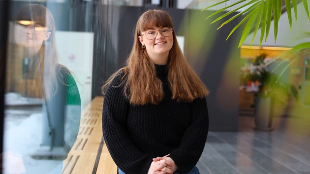 Student som sitter vid ett fönster. 