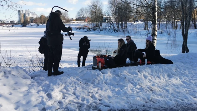 Personer sitter och grillar och blir samtidigt filmade.