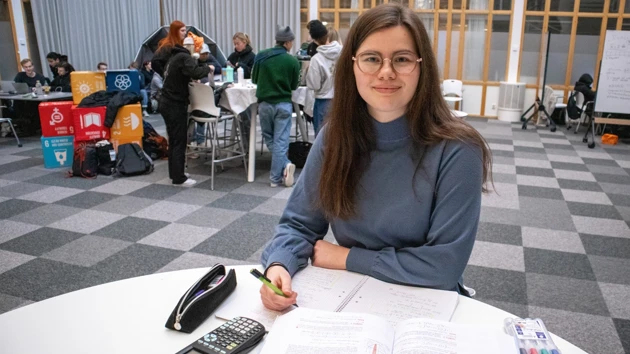 Bild på Hanna Berggren sittande vid ett bord med sina matematikböcker