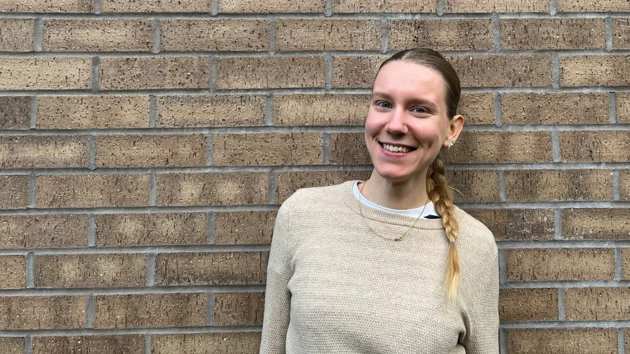 Porträttfoto på Ida Bengtsson stående mot en tegelvägg