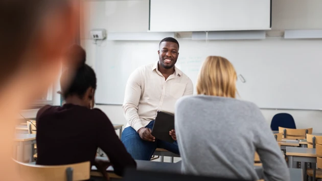 En grupp människor som sitter i ett klassrum.