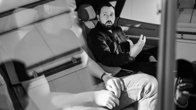 Bild på Juan Pablo Bernal sittande i en bil, en person i skugga till vänster om honom