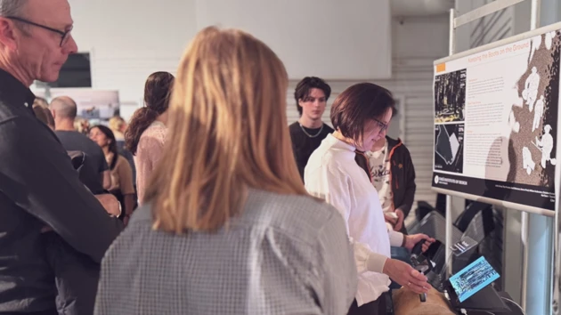 A group of people standing around a poster.