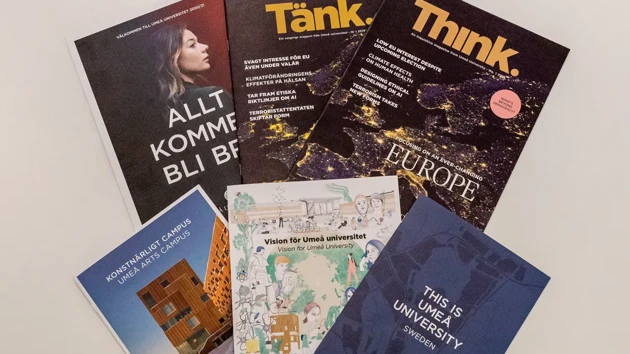 University magazines and brochures spread out on a table.