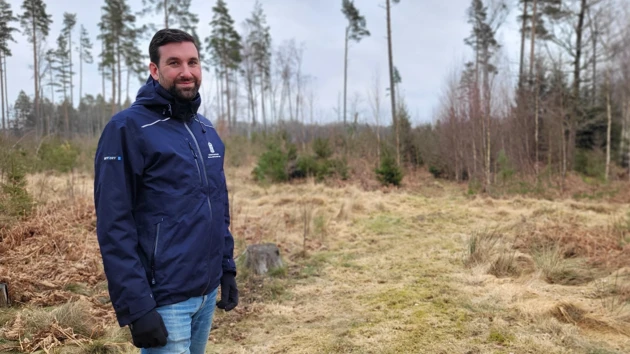 Bild på Joel Avenius med skogsmark i bakgrunden