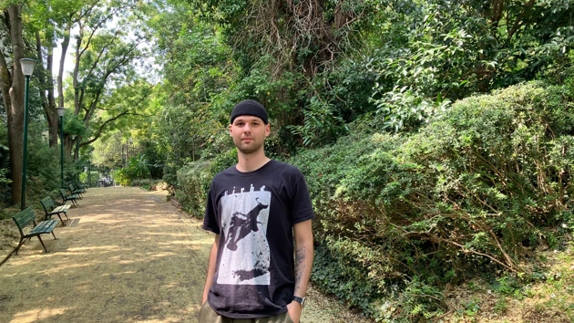 Photo of Konstantin Schäfer, in the background a forest path and trees