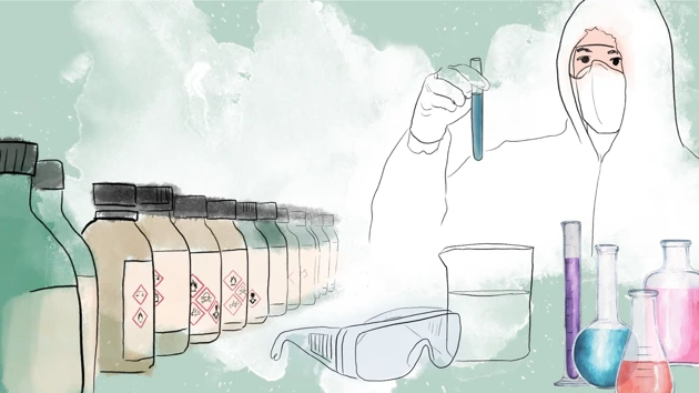 En person med skyddskläder håller i ett provrör med flaskor, skyddsglasögon och labbutrustning i förgrunden.