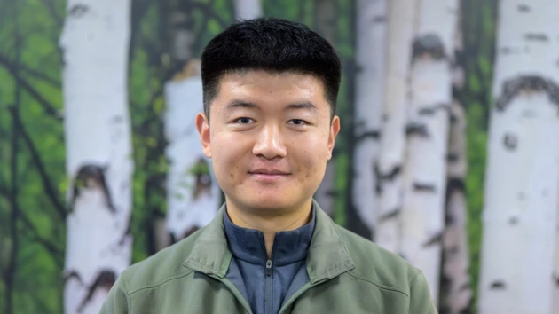 En man som står framför en målning av björkar