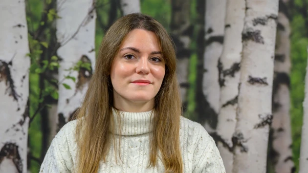 En kvinna som står framför träd