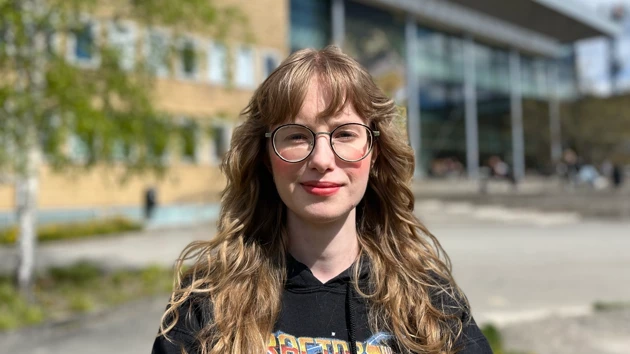 Student standing by the campus pond at Umeå University