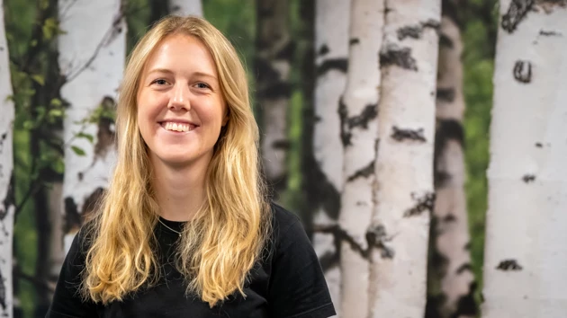 En kvinna som står framför träd