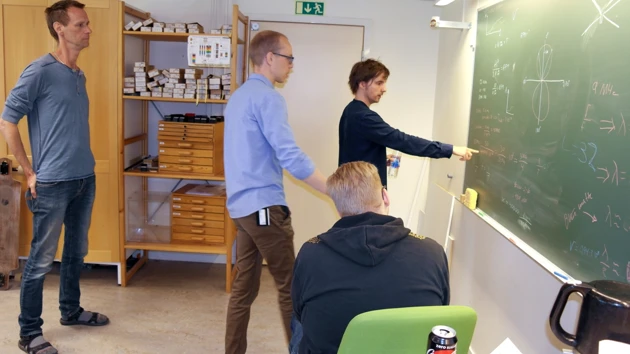 Bild på lärare och studenter vid tavlan i elektroniklabbet