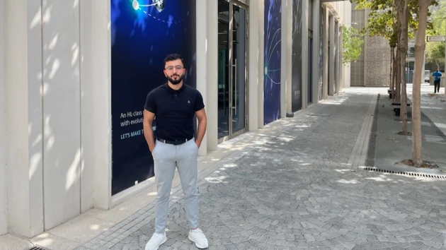 Photo of Mohammad Mshaleh standing outside Siemens' office in Dubai