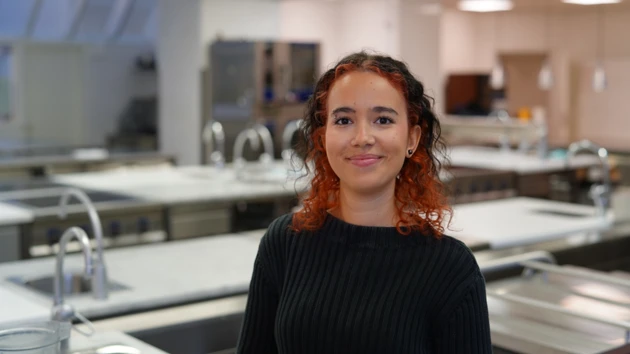 Porträtt av gastronomistudent i köksmiljö. 
