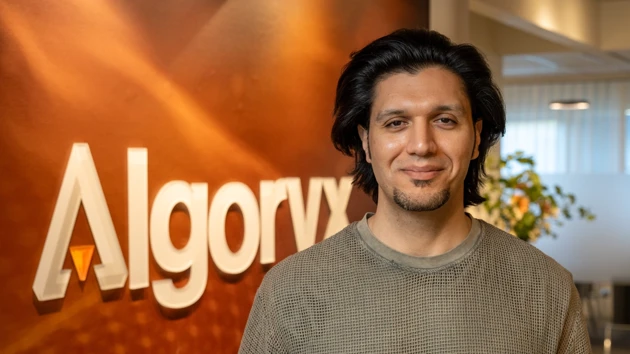 Portrait photo of Omar Abrahamsson, in the background Algoryx's logotype