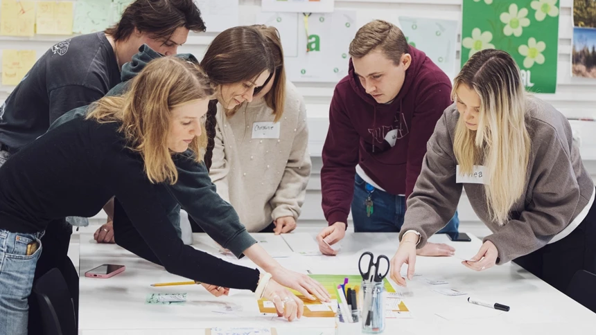 A group of people standing around a table.
