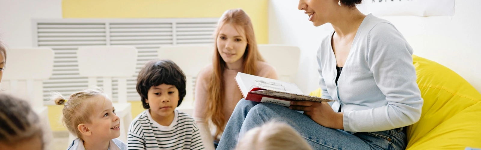 Förskolelärare läser för en grupp barn