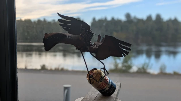 Skulptur i plåt av fågel med ölburk